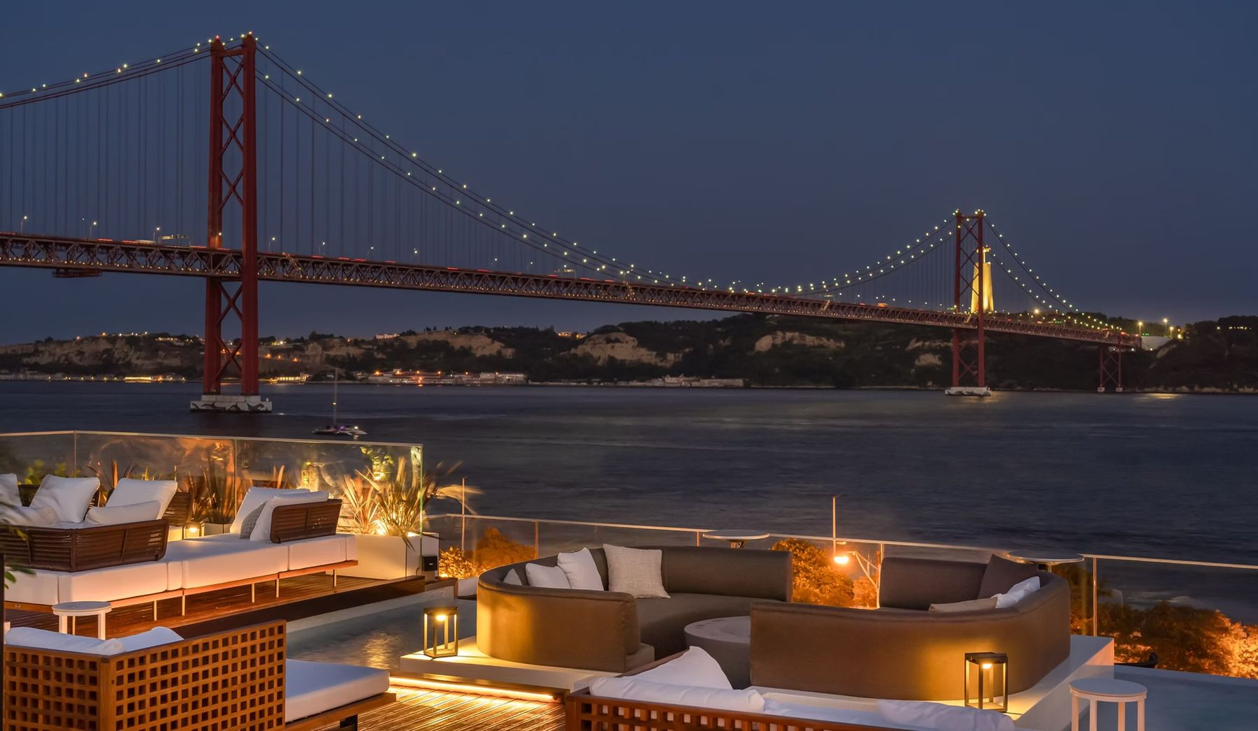 Rooftop à noite com a ponte iluminada · Hyatt Regency Lisboa Residences